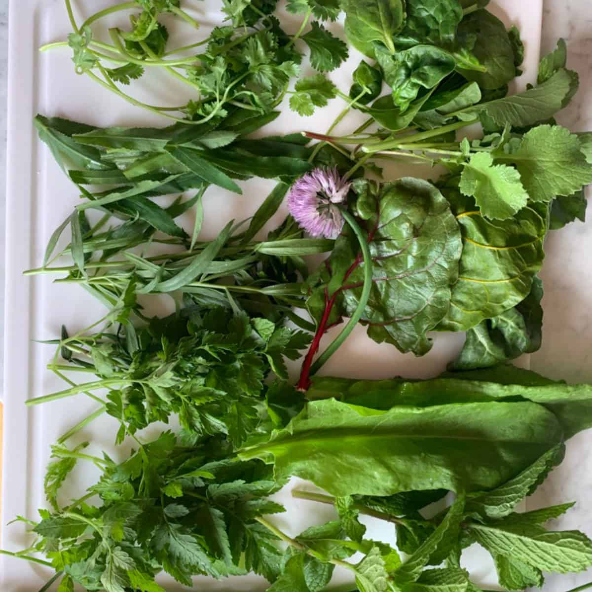 Various greens on a cutting board.