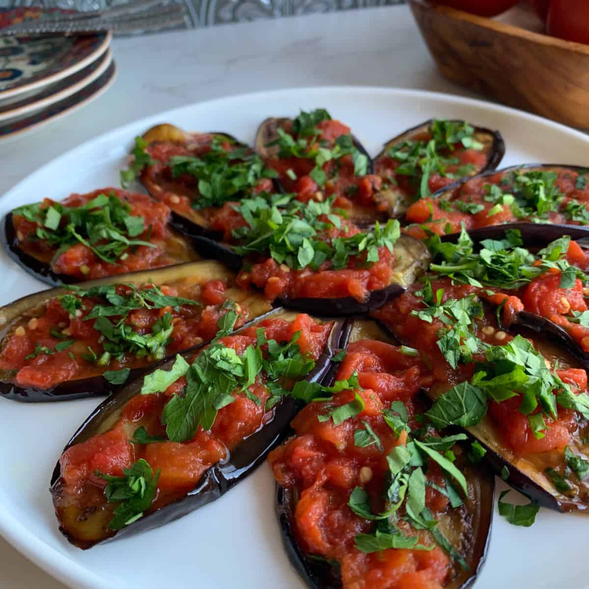 The pan fried eggplants are on a serving plate. 