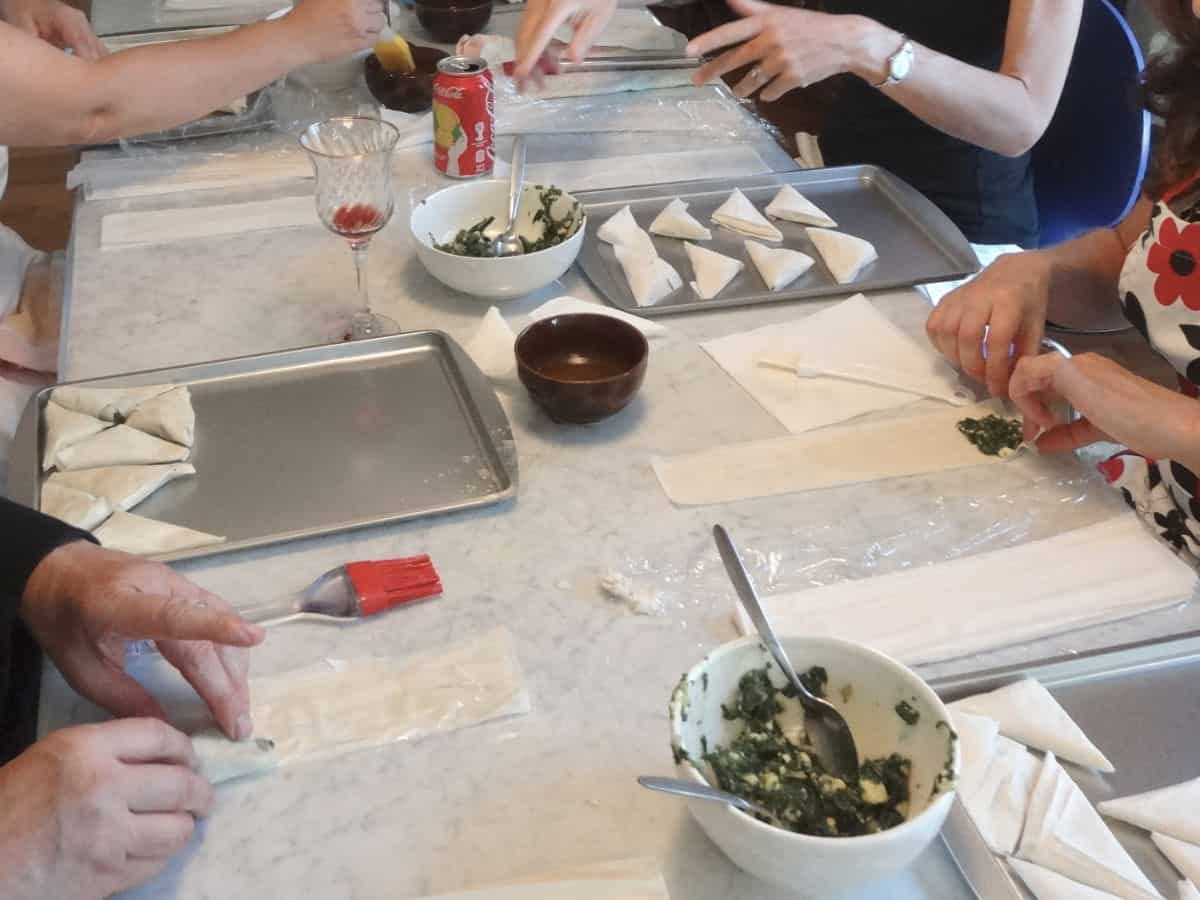 In the spanakopita class, students are folding the pies. 