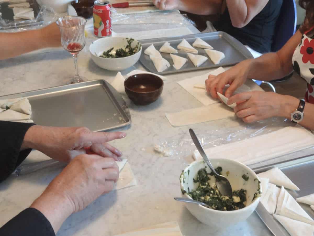 In the spanakopita class, students are folding the pies. 