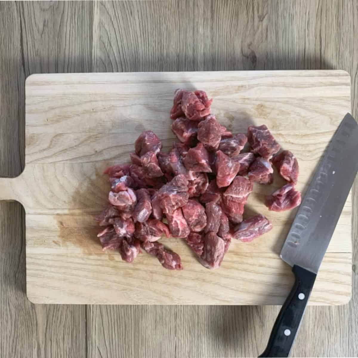 Three-bean-chili beef chunks on a cutting board.
