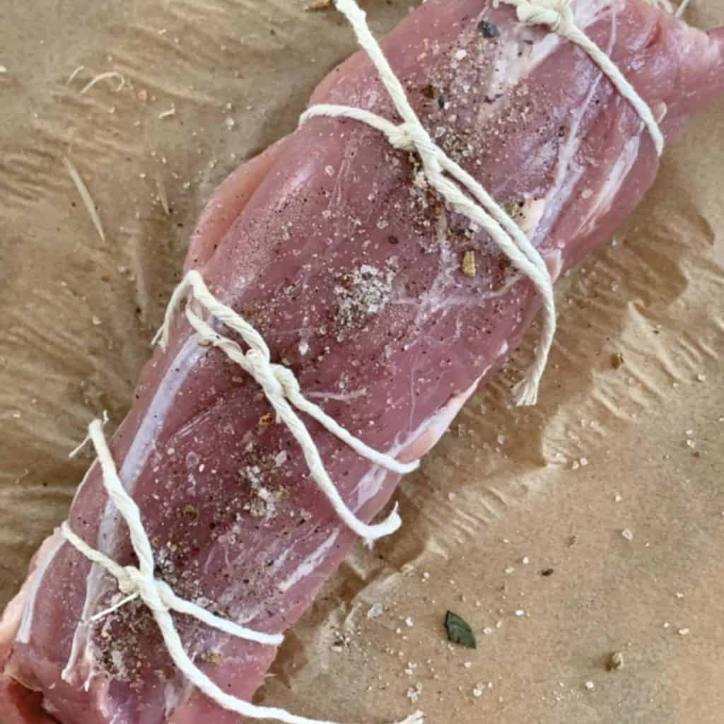 Trussing the meat with the kitchen twine.