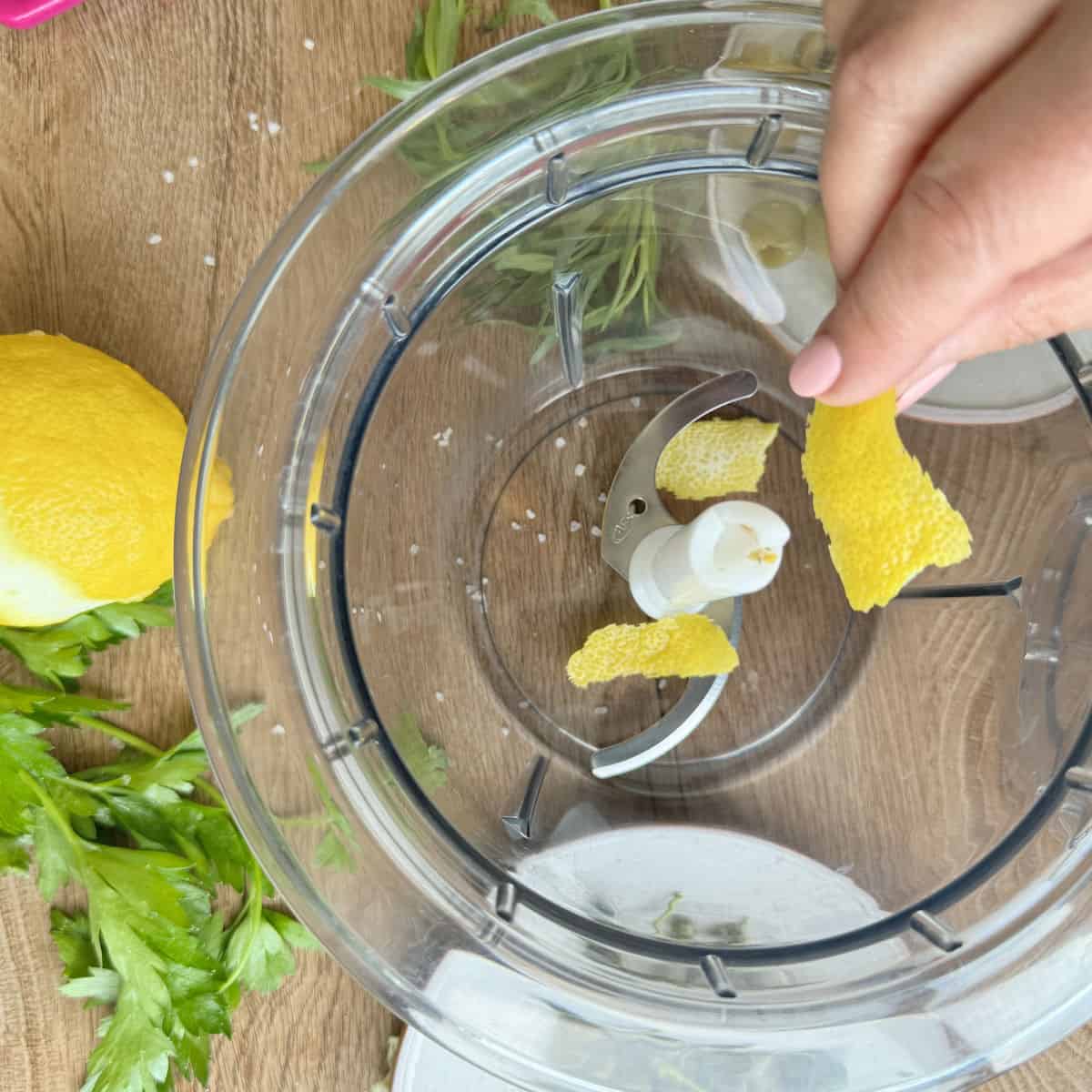 Adding lemon zest into the food processor.