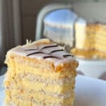 A slice of Esterházy Torte and a cloche on the background.
