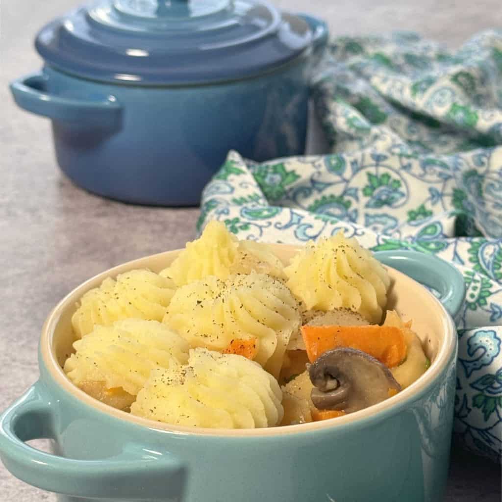 Piping the mashed potatoes on a stew.