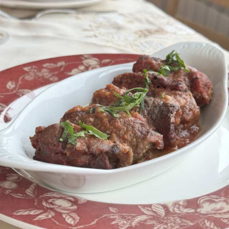 Braciole rolls in a dish with parsley.