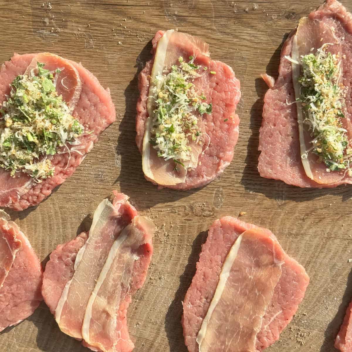 Process shots of making braciole, adding slice of prosciutto.