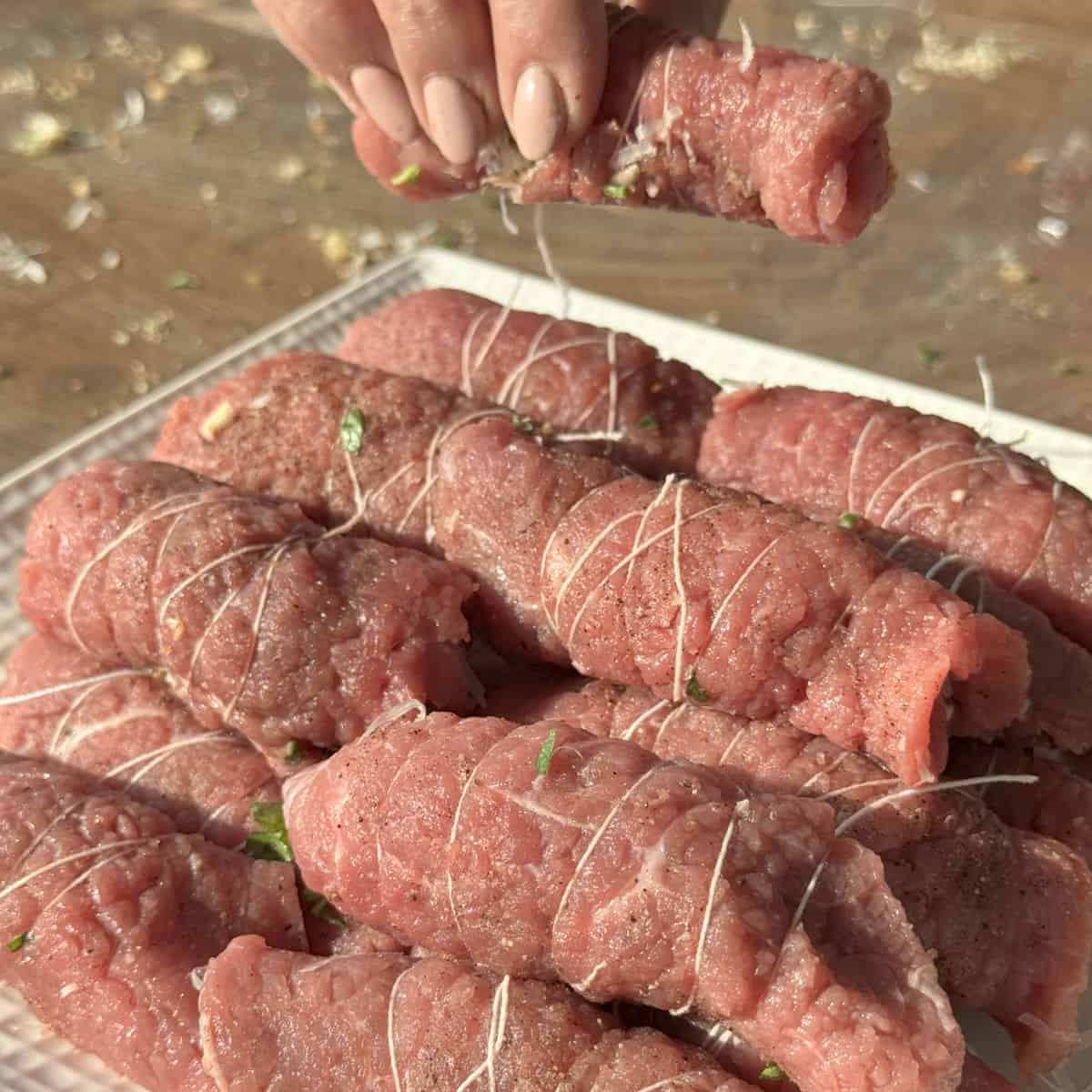 Process shots of making braciole.