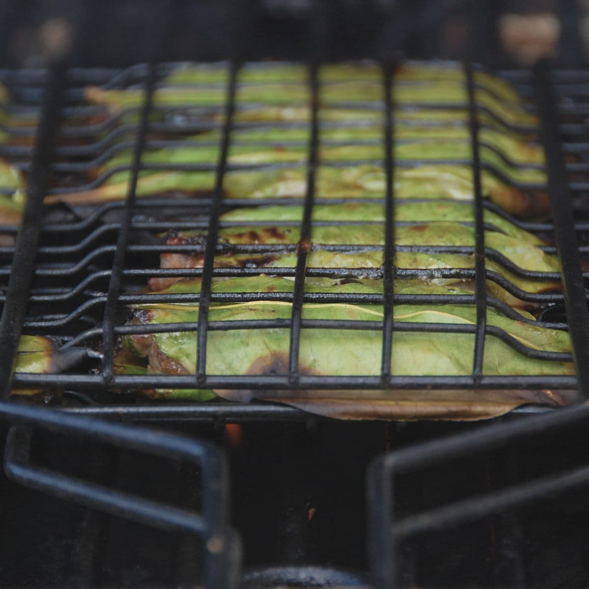 Meatballs are arranged in a grilling basket.