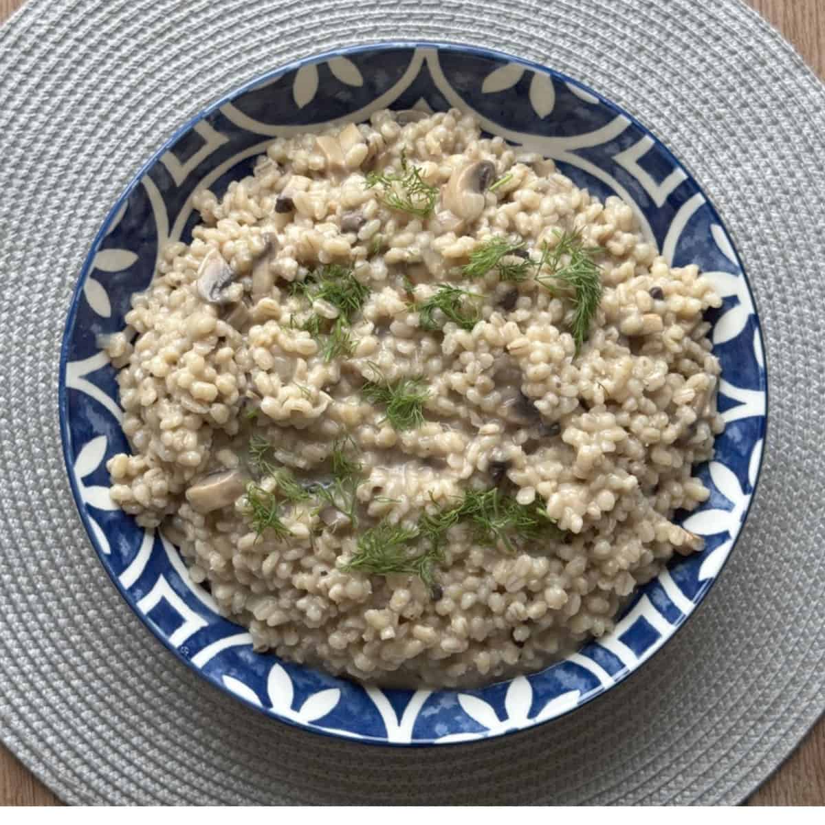 Overhead shot of a pearl barley risotto with chopped dill.