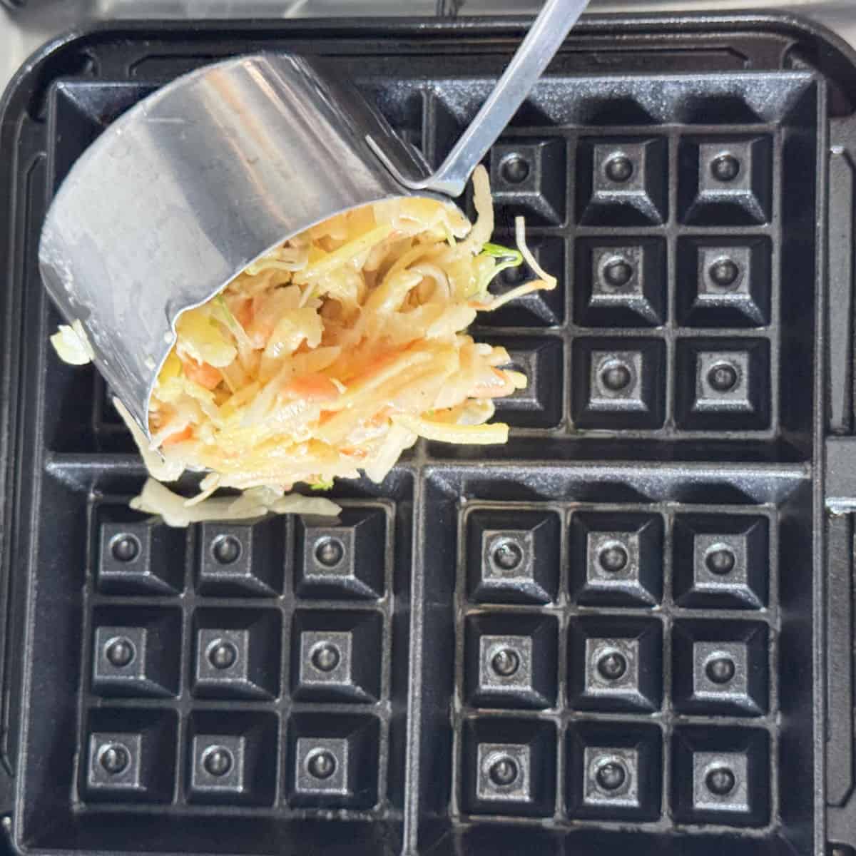 Making veggie waffles in a waffle iron.