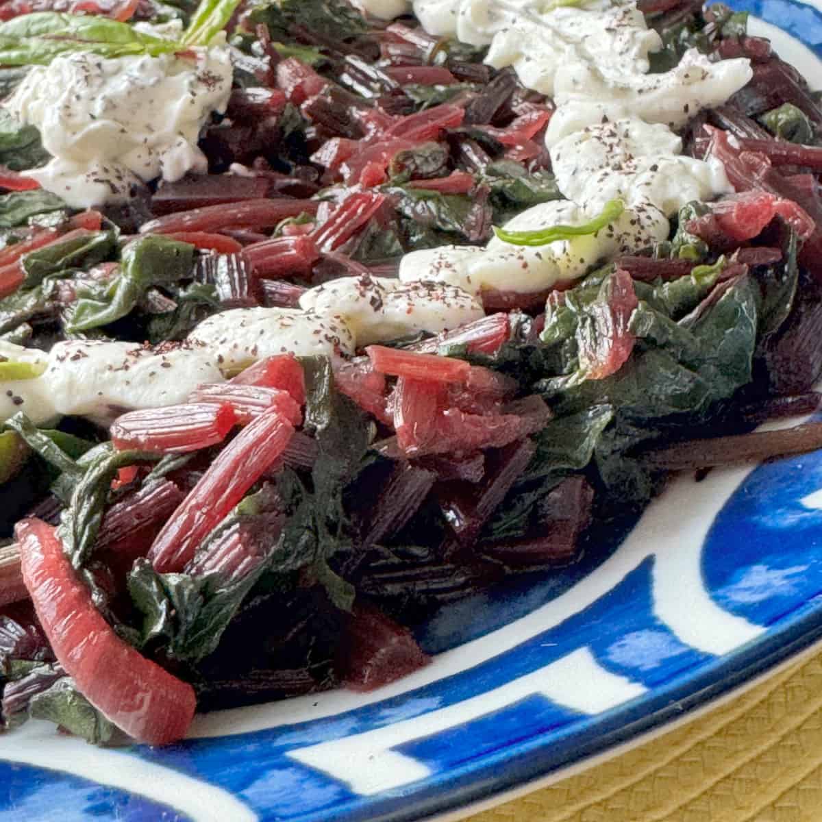 Side view of the beetroot greens in a blue plate.